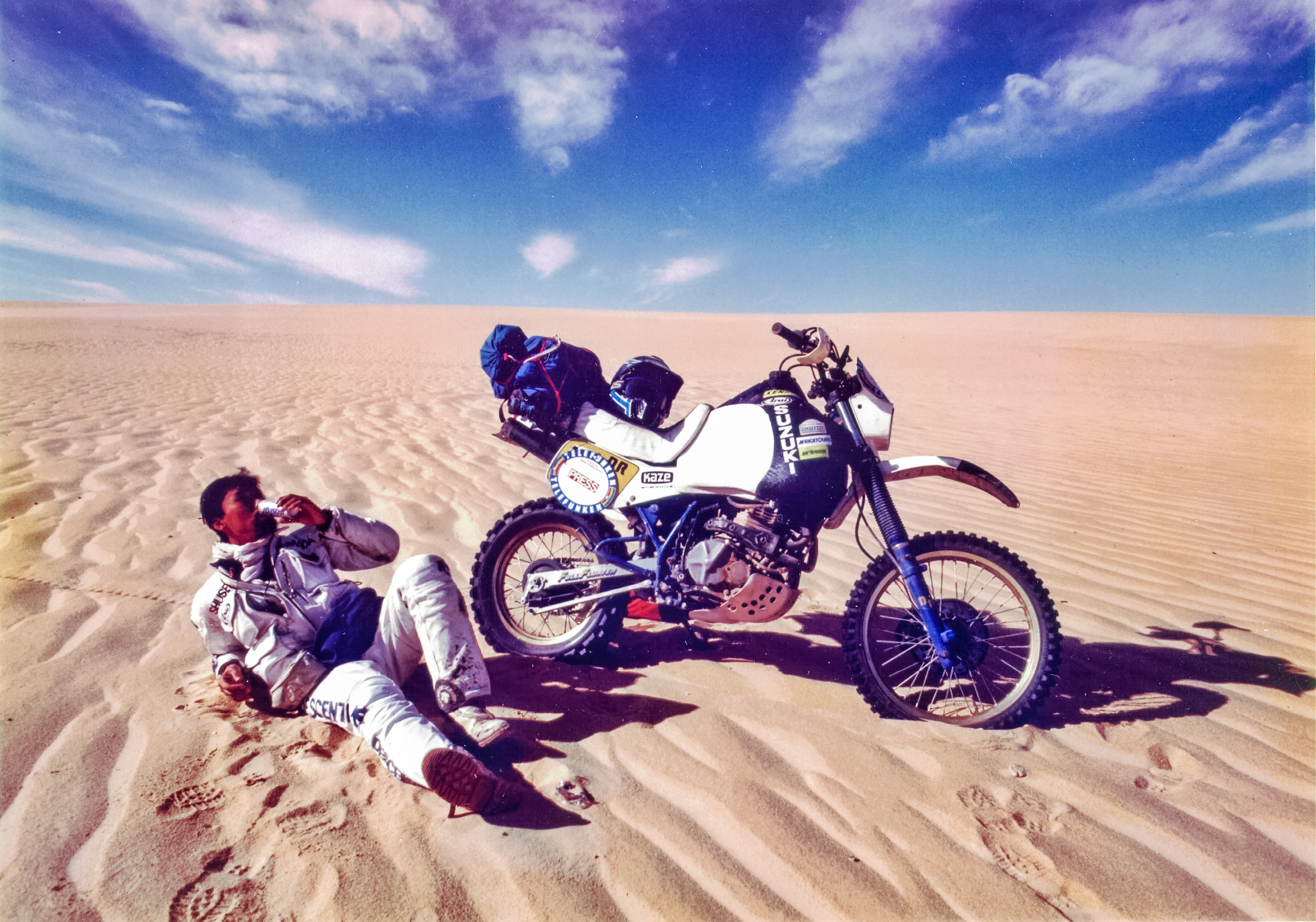 砂漠でバイクのお横に横たわり休憩
