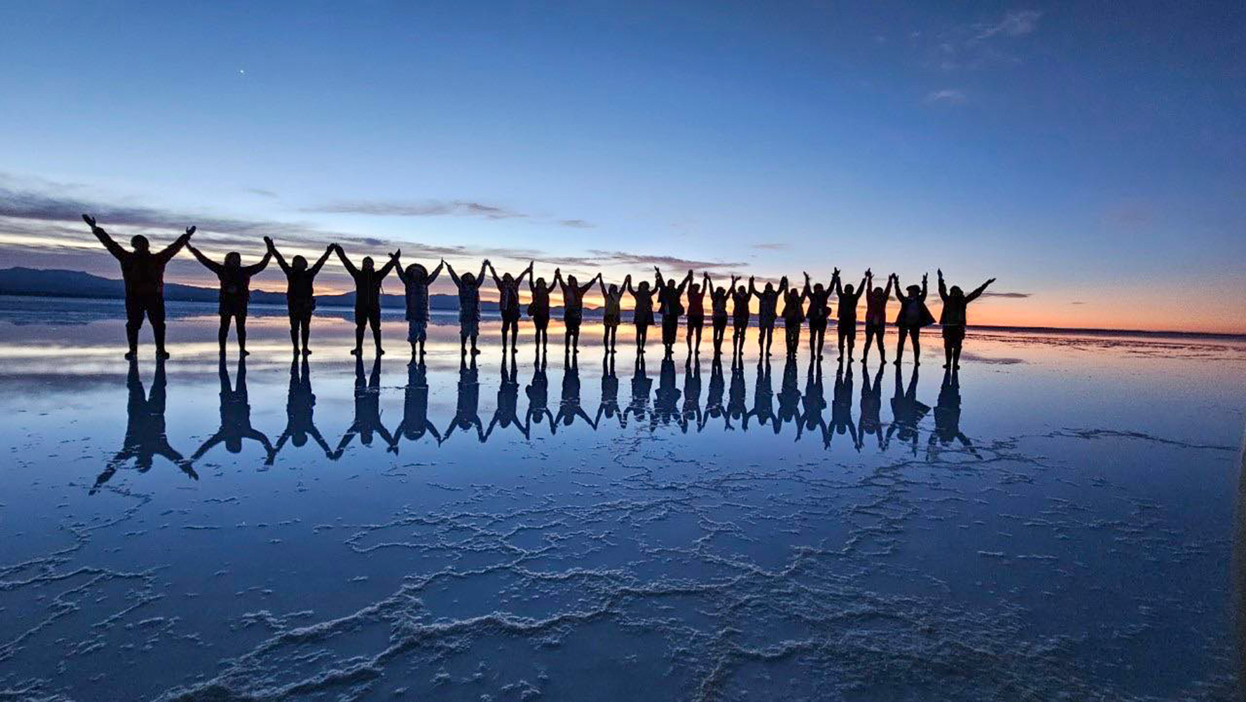 ウユニ塩湖で万歳をする人々